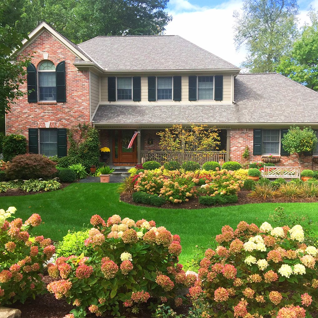 Transform Your Home: Stunning Dark Green Shutters on a Red Brick House